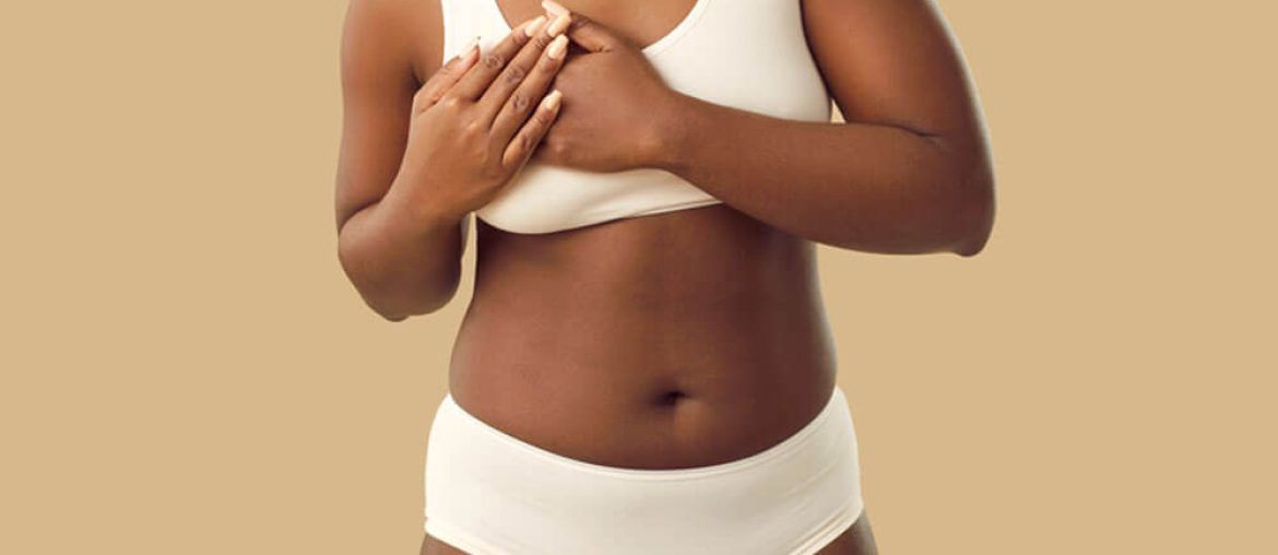 Beautiful plus size young black woman in underwear touches her chest when she feels strong pain