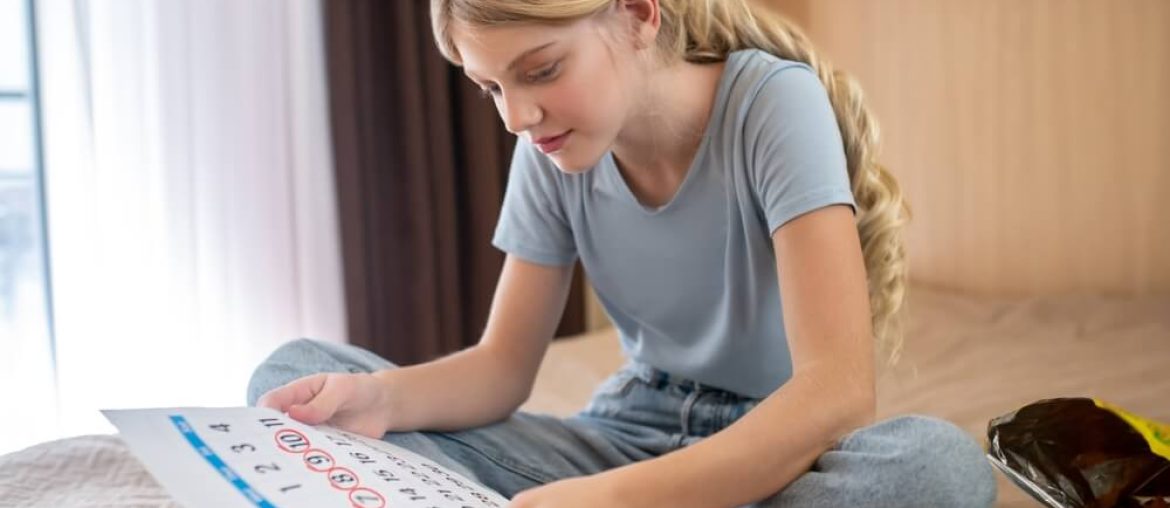 A blonde teen ,marking days of her periods in a calendar