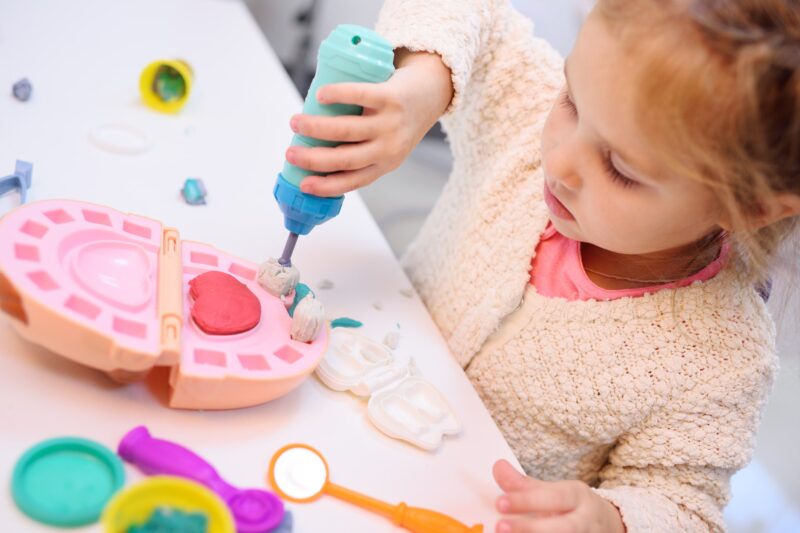 Girl playing with model of mouth