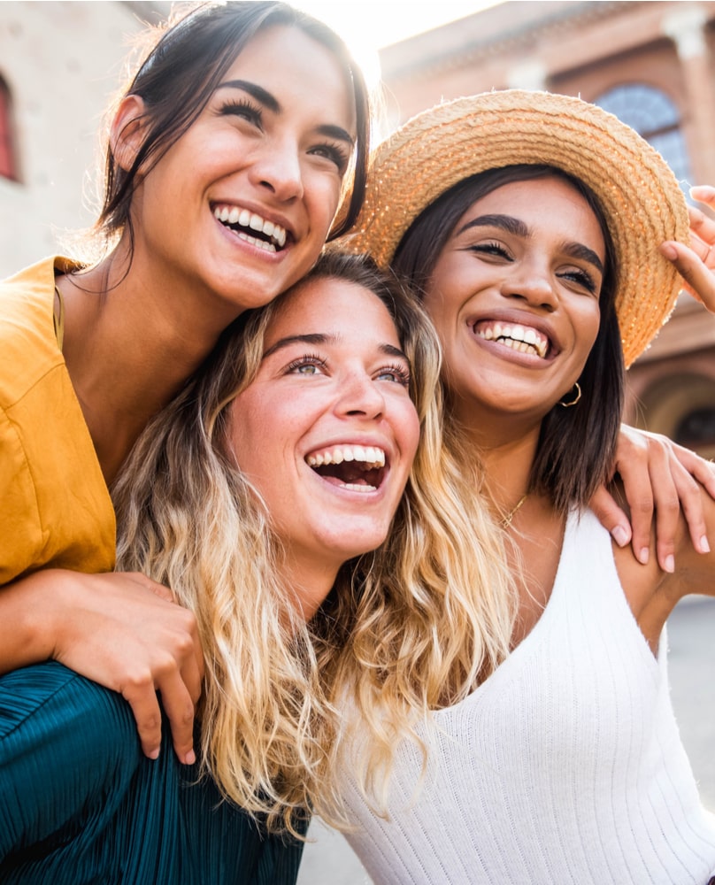 Three young women having fun on city street outdoors