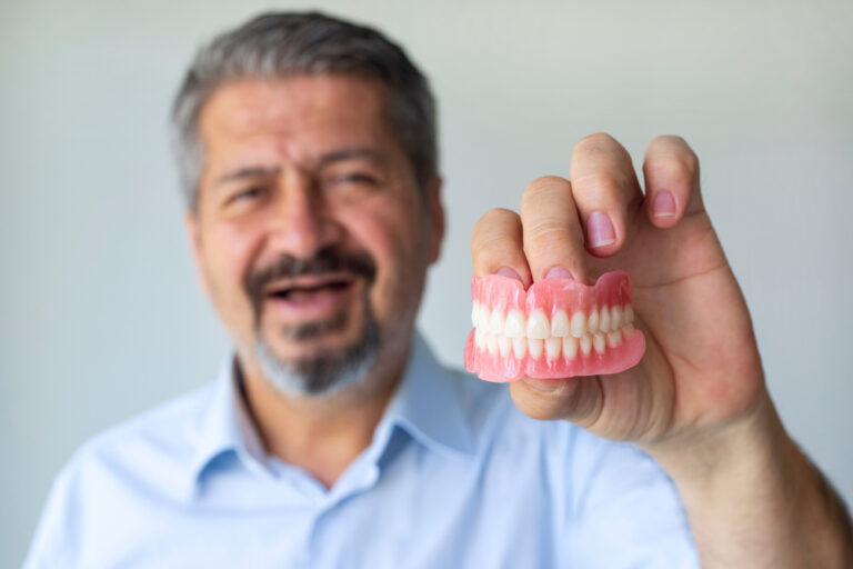 Man Holds His Denture