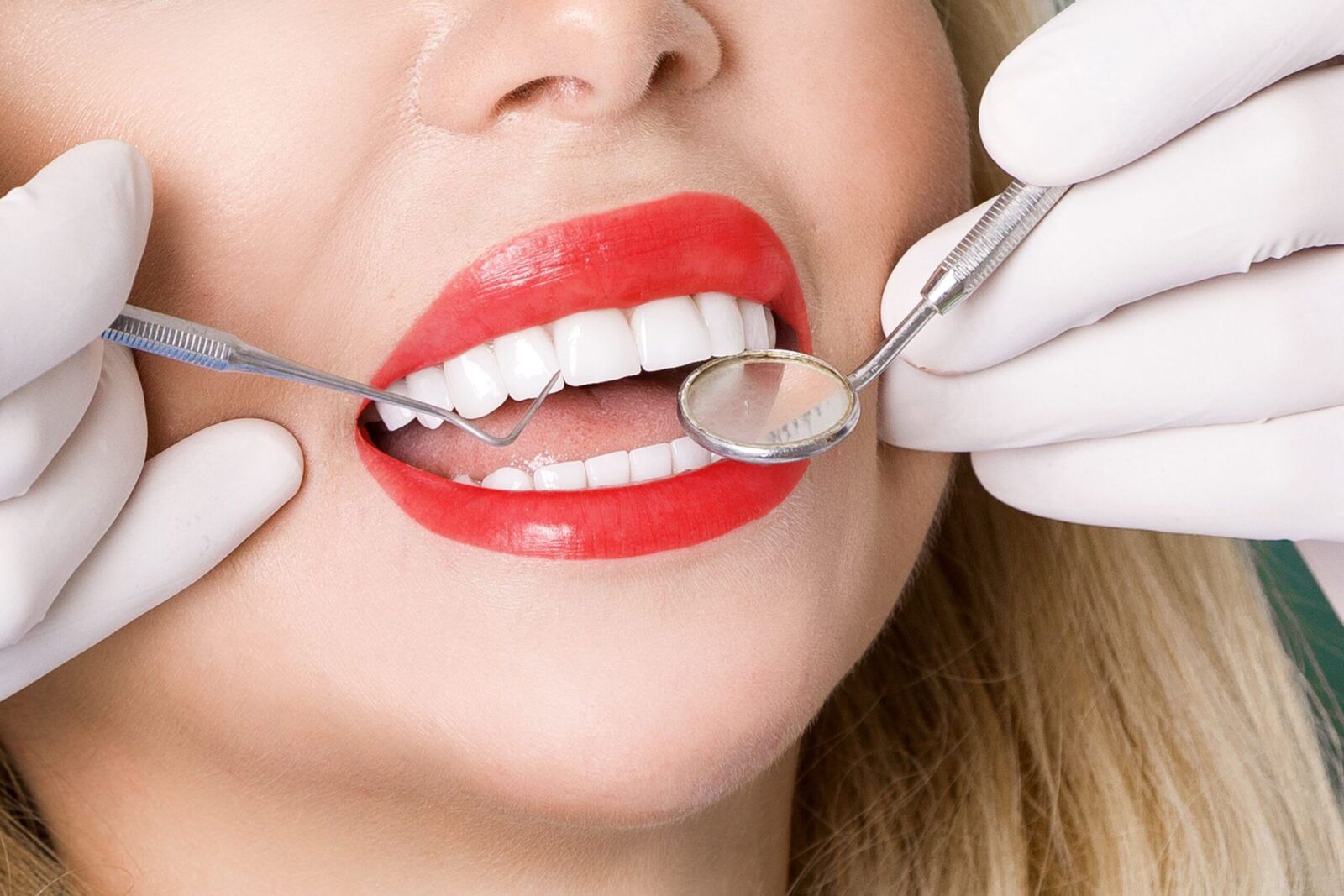woman with red lipstick having dental exam