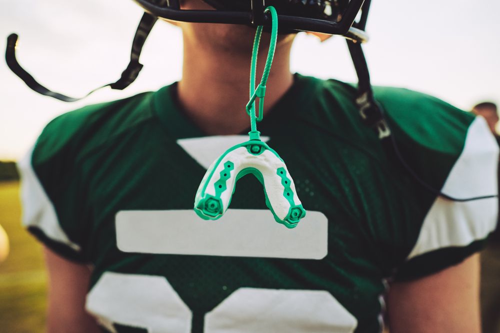 An athlete wearing a Sports Mouth Guard on their helmet