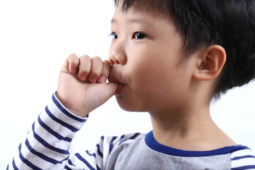 Close up little Asian boy sucking thumb