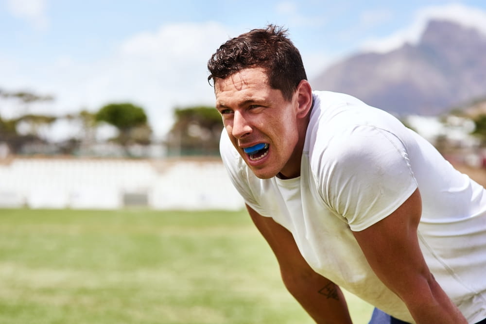 Man, rugby and tired on match at field with sweat for sports game