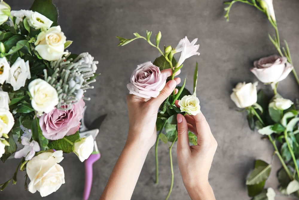 Female florist making beautiful bouquet at flower shop