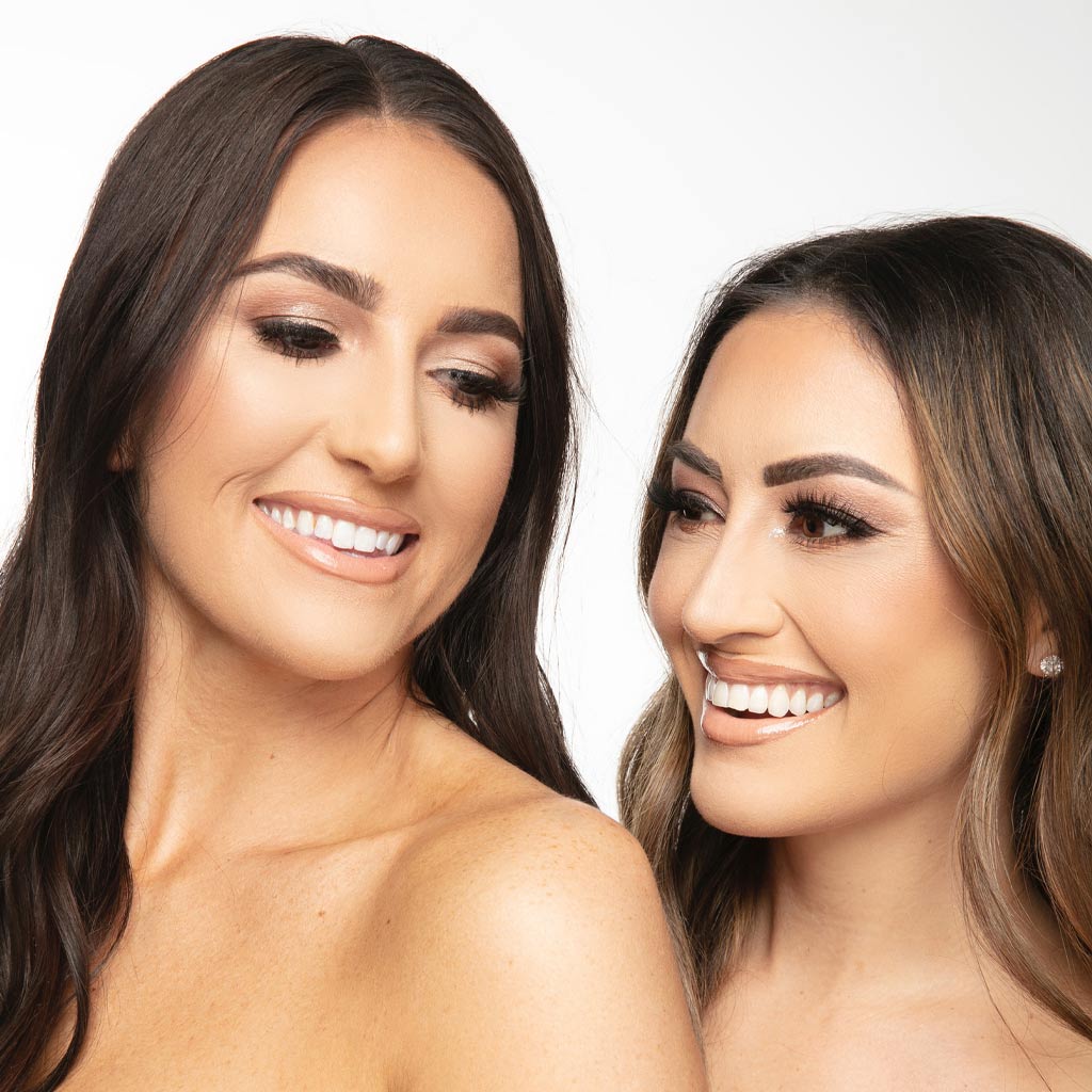 Two young woman smiling together