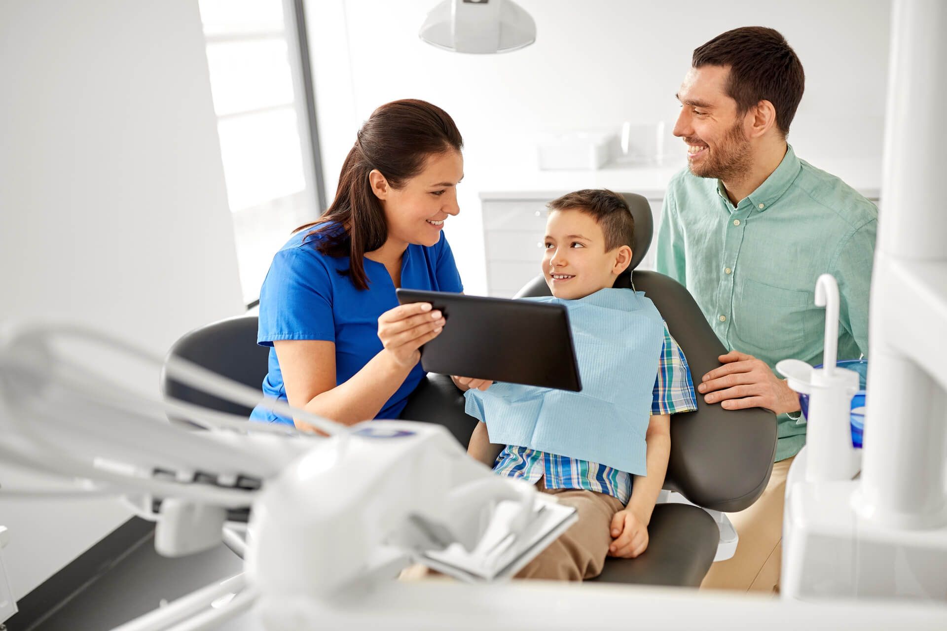 dentist showing tablet pc computer to kid patient