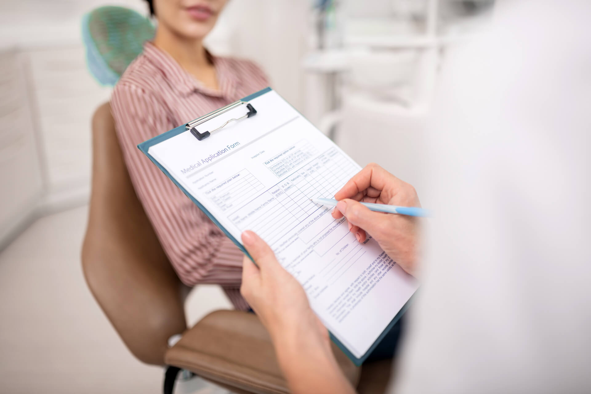 Dentist with a pen in her hand preparing medical application