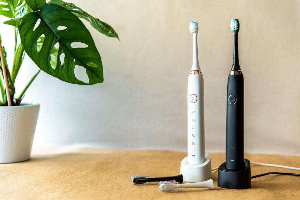 Modern rechargeable sonic or electric toothbrush set with charger in bathroom