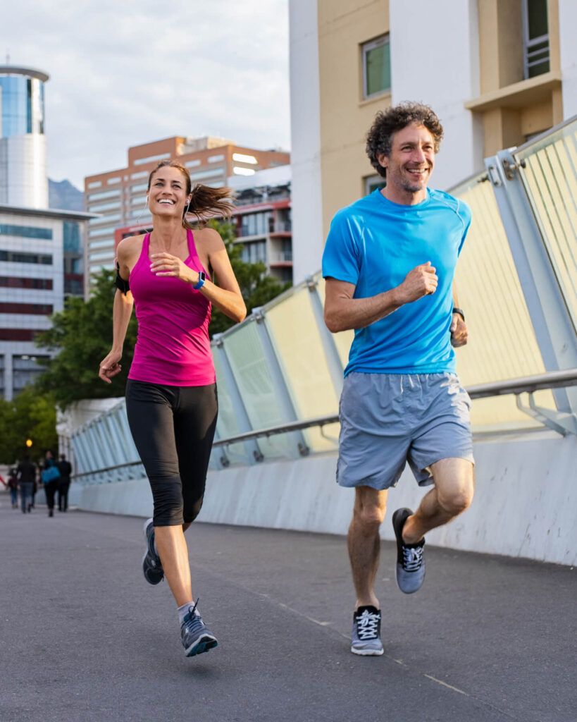 Happy man and beautiful woman jogging together city bridge