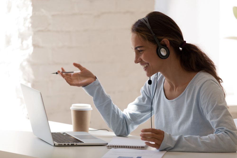 smiling lady wearing headset, communicating with client