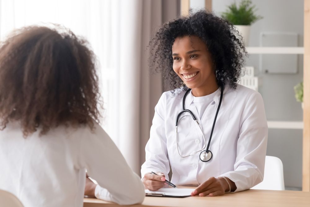 Smiling female doctor talking to teen patient