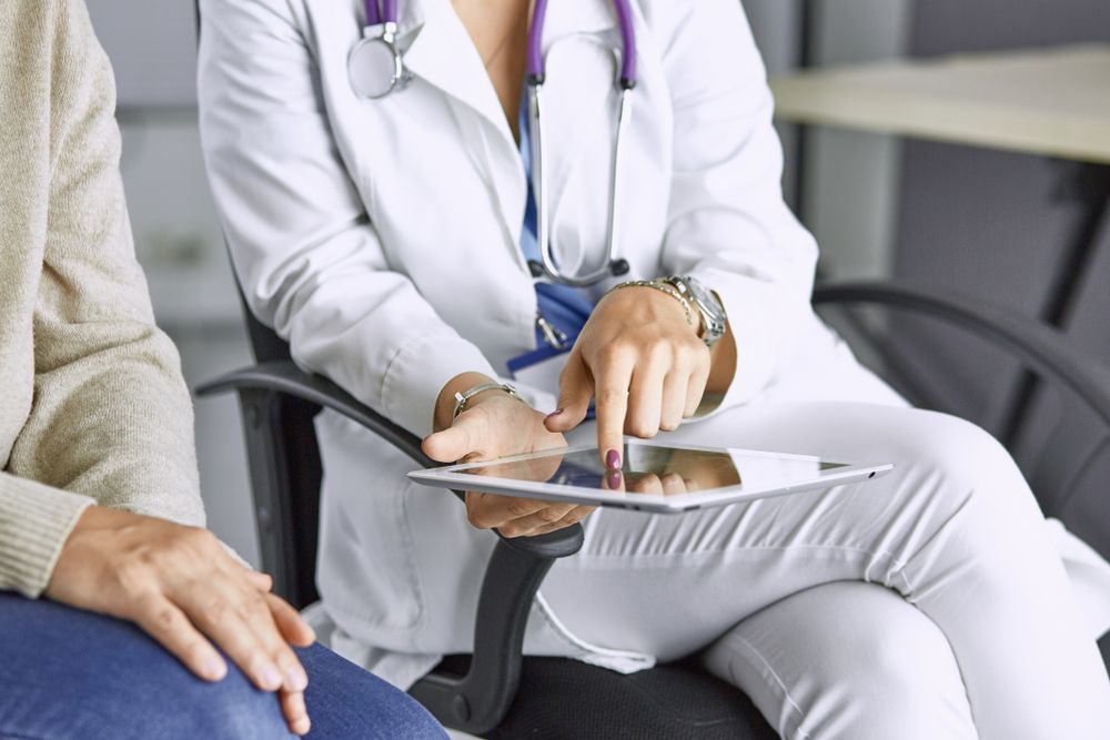 Female doctor talking to a patient on a tablet