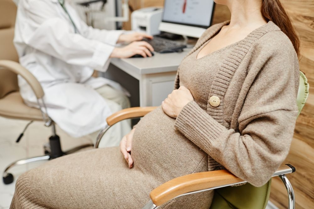 pregnant young woman consulting obgyn in medical clinic