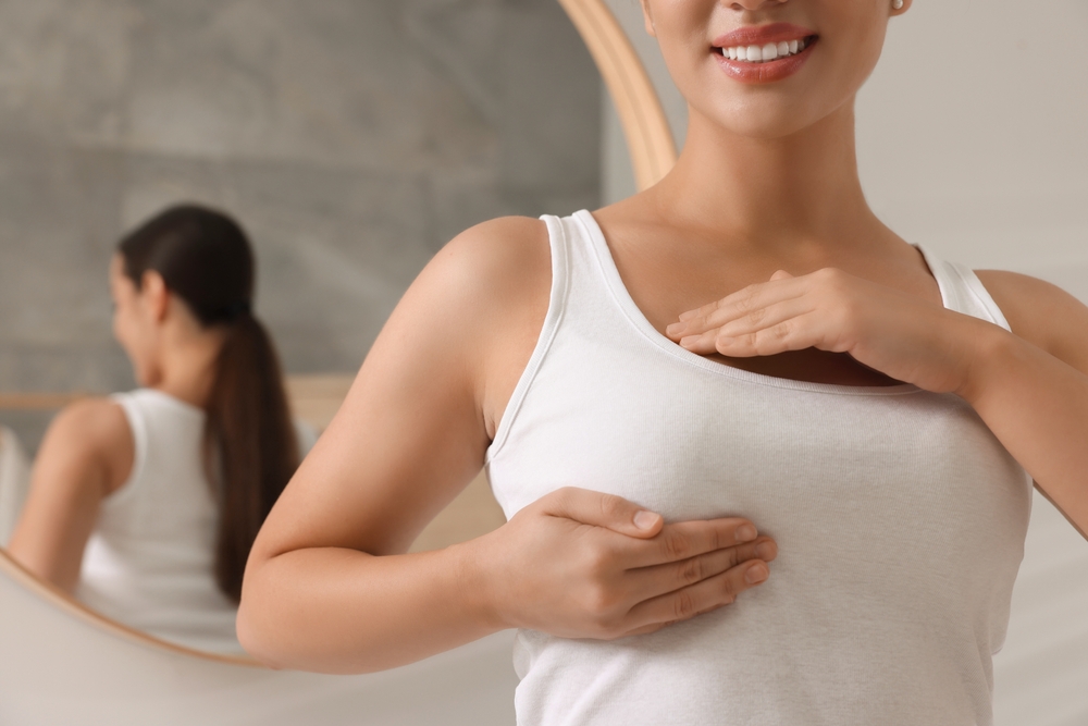 Woman doing breast self-examination in bathroom, closeup