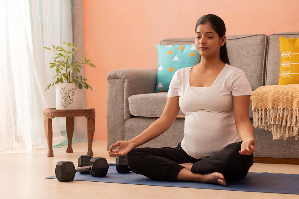 Pregnant woman meditating at home