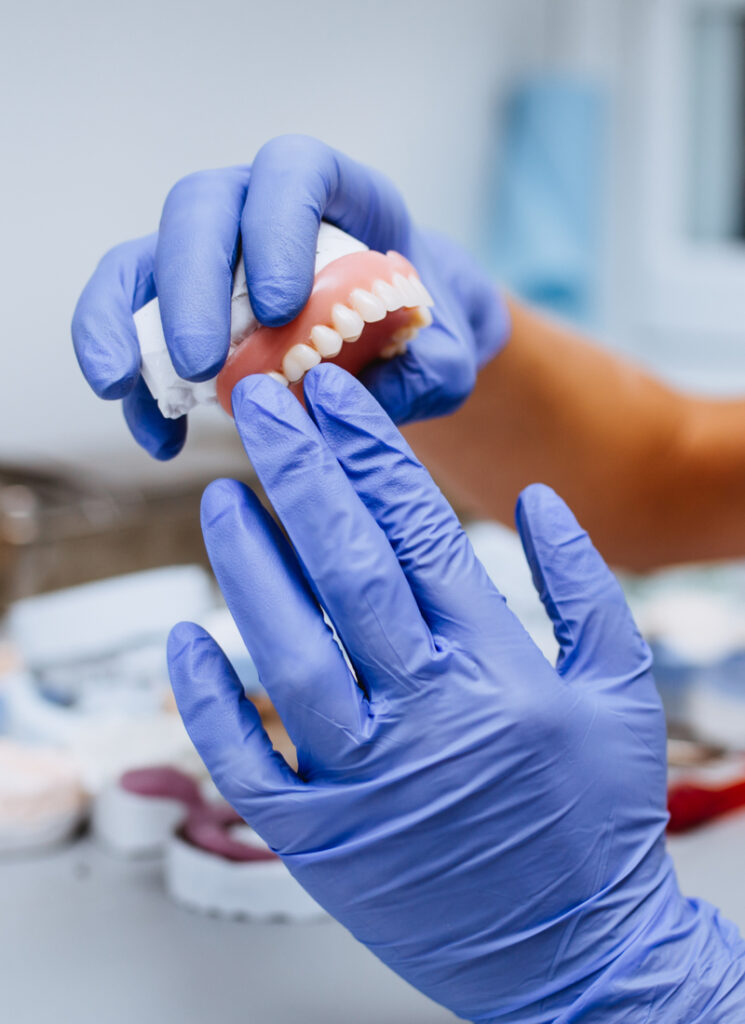 Close up of prosthetic's hands while working on the denture