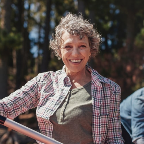 Portrait of happy senior woman in a kayak holding paddles