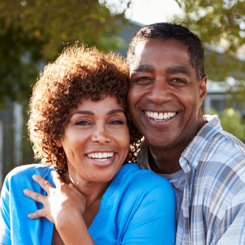 Portrait Of Mature Couple Looking Over Back Yard Fence