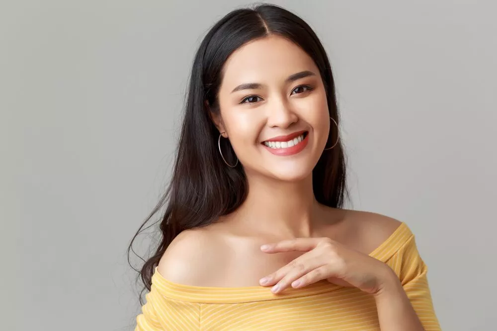 young happy attractive Asian woman wearing yellow