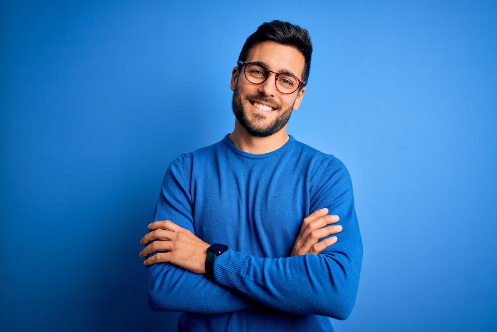 handsome man with beard wearing casual sweater and glasses