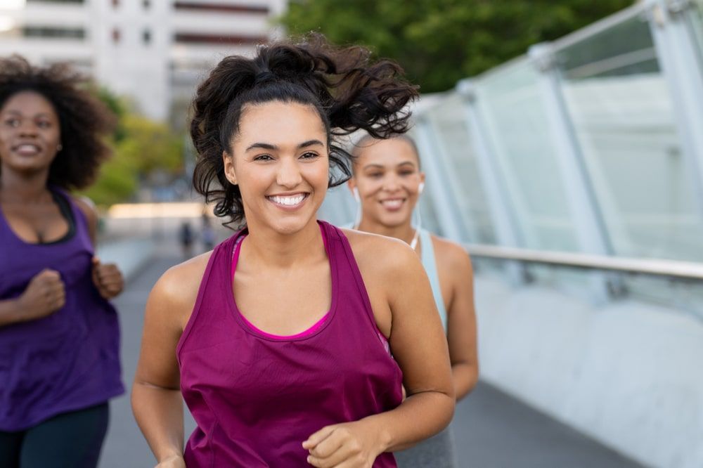 happy curvy woman jogging on bridge