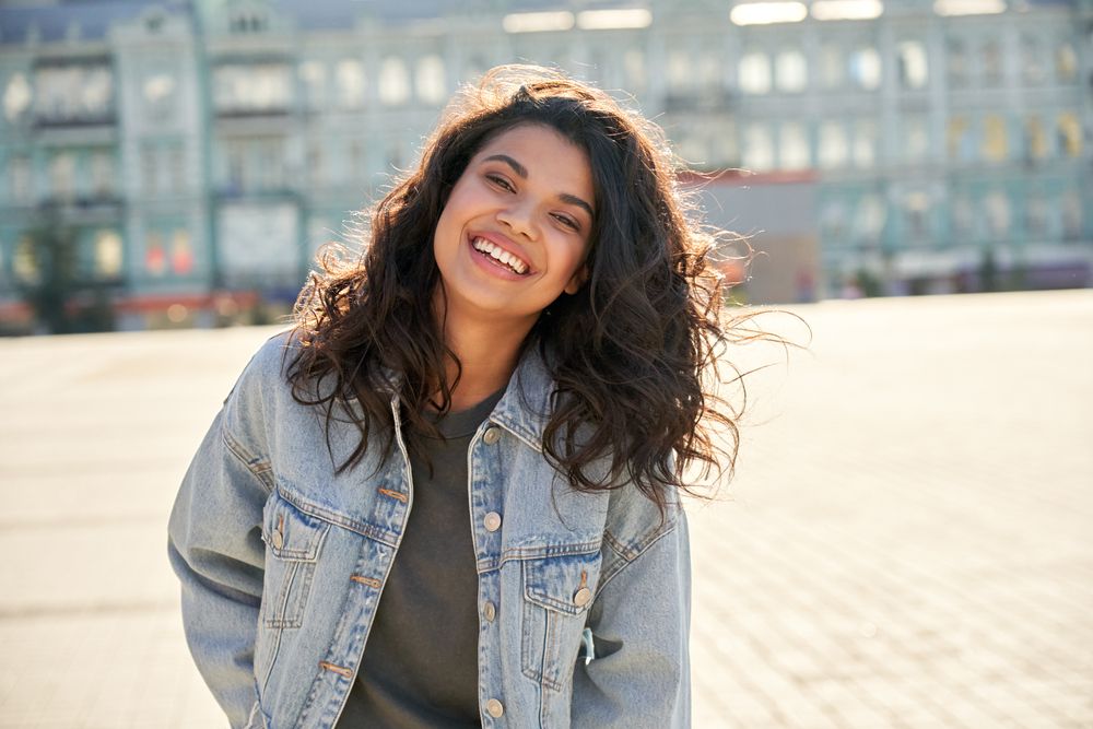 Young woman wearing denim jacket laughing