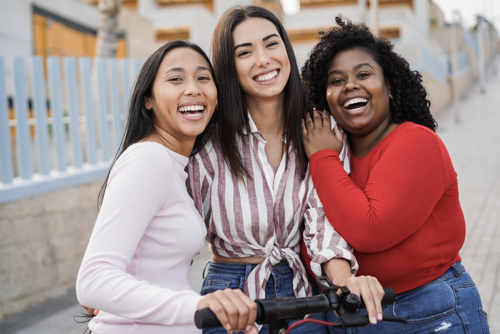 Happy girls having fun with electric scooter