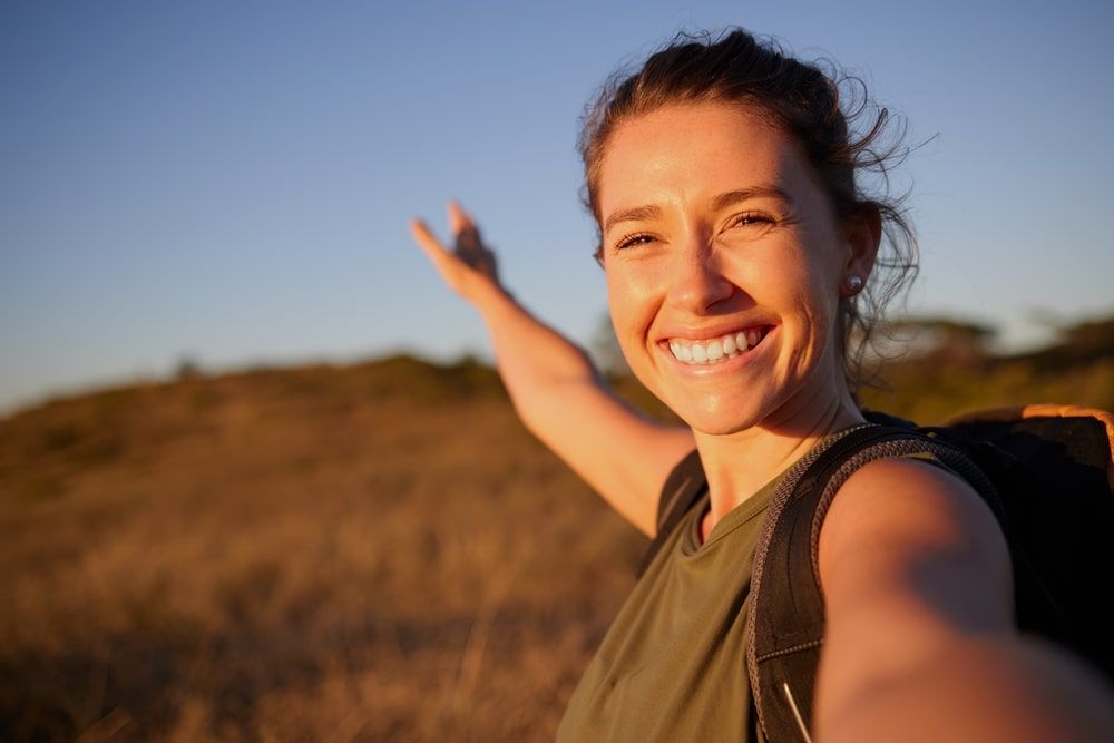 young woman taking a selfie while out hiking
