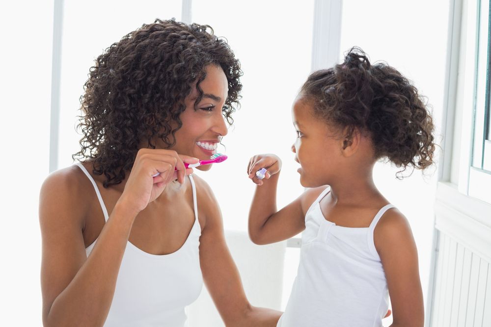 Pretty,Mother,With,Her,Daughter,Brushing,Their,Teeth,At,Home