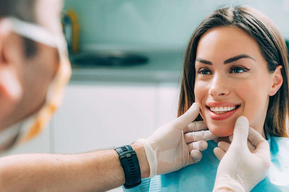 Young smiling woman with beautifiul teeth, having a dental inspection