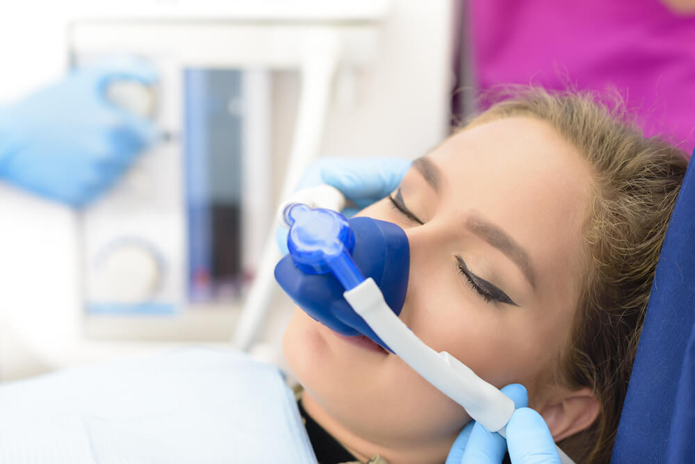 Beautiful getting woman inhalation sedation at dental clinic