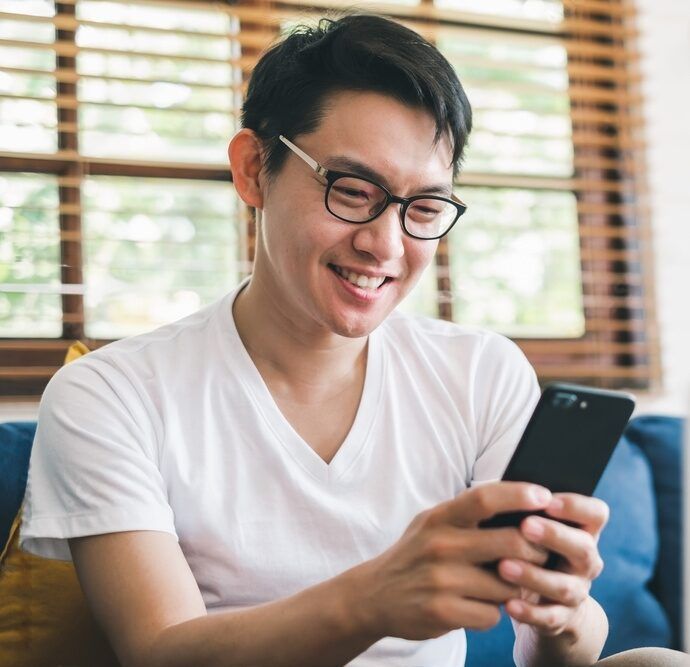 Asian man with glasses sing mobile phone and smiling