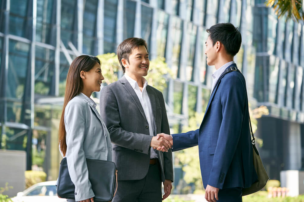 asian business associates meeting in the street in downtown