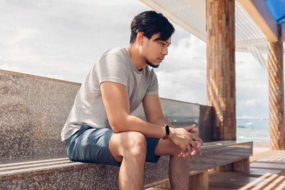 Lonely Asian man sitting in the hut by the sea chilling the atmosphere.
