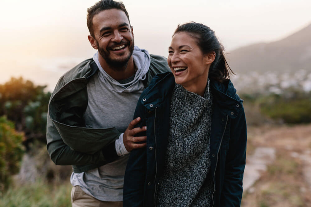 Portrait of couple walking through pathway on mountain