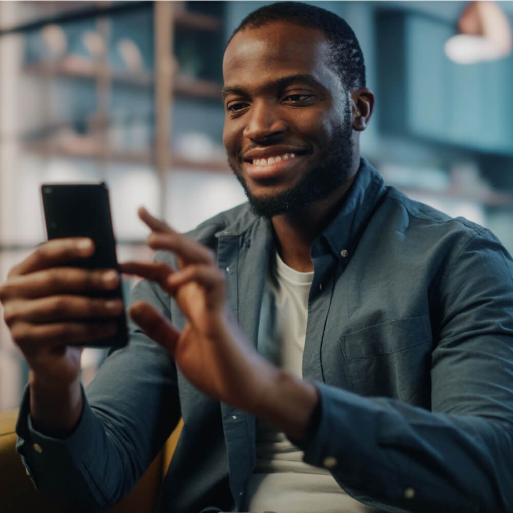 Excited Black African American Man Using Smartphone