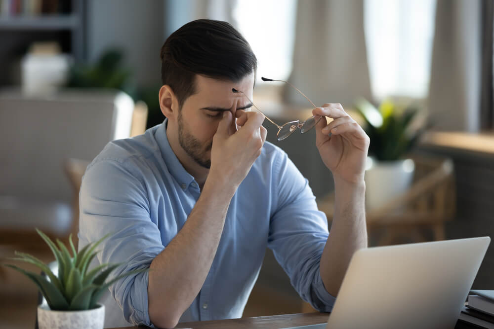 Tired exhausted businessman massaging nose bridge