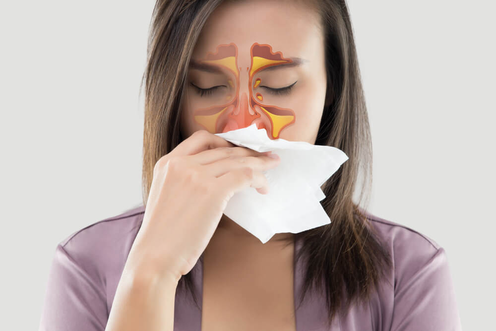 Asian women in satin robes feeling unwell and sinus against gray background. Dust allergies. Flu. People caught cold and allergy.