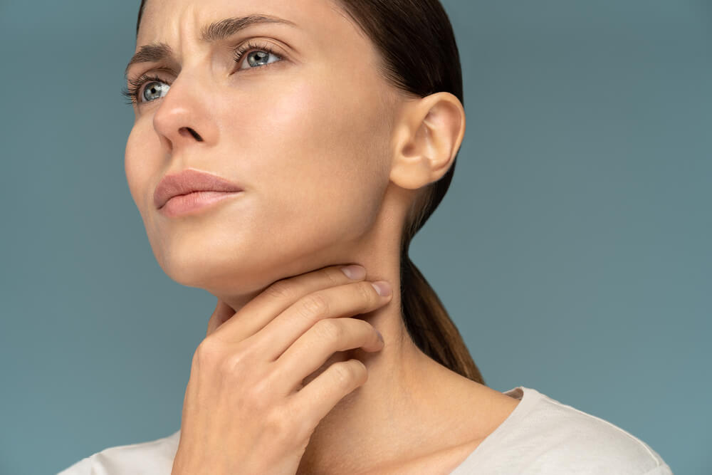 Closeup of sick woman having sore throat, tonsillitis, feeling sick,