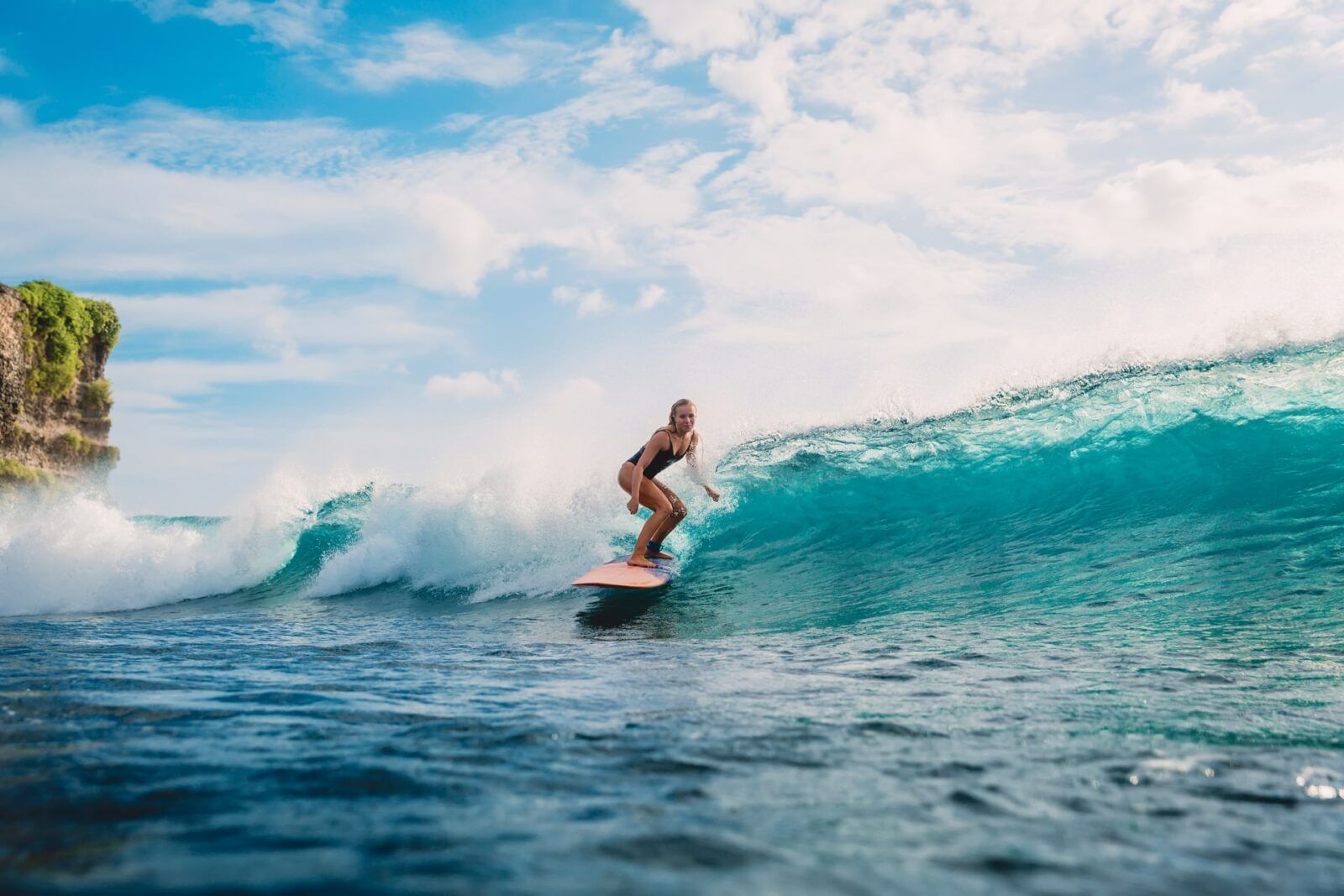 Surfer woman on surfboard during surfing. Surfer and ocean wave