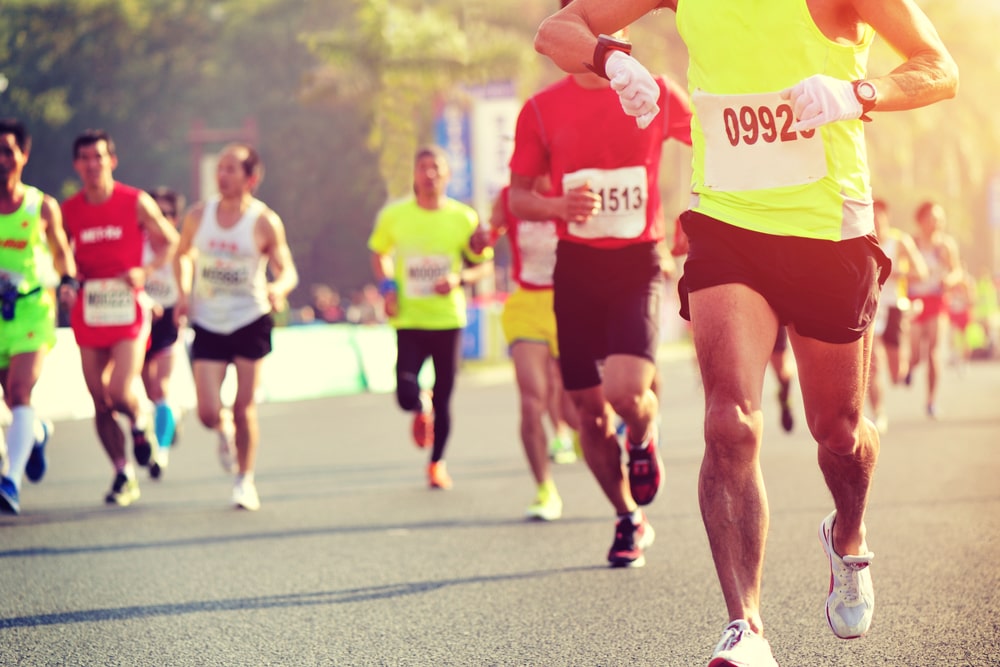 Marathon running race, male runner checking the time