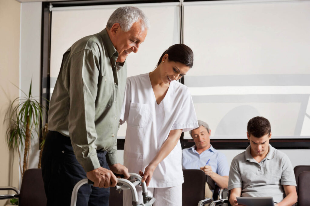 Senior man being assisted by female nurse to walk