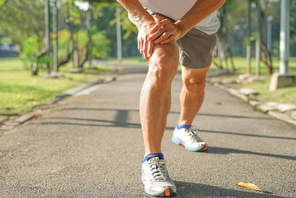 senior man stretching legs muscle before running or jogging