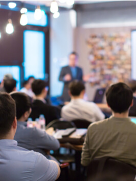 Conference Speaker Presenting to Audience