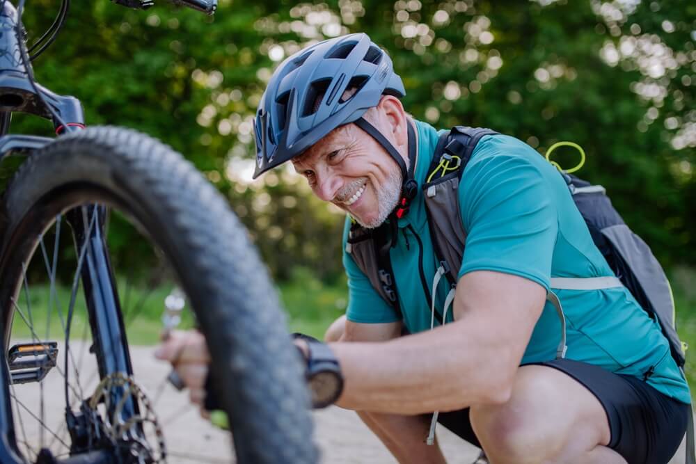 Active senior man repairing bicycle