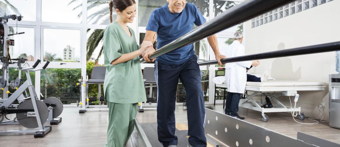 Physiotherapist Standing By Smiling Patient Walking Between Para