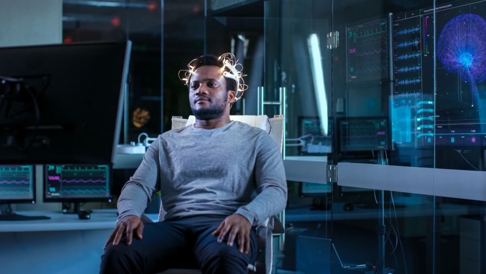 Man,Wearing,Brainwave,Scanning,Headset,Sits,In,A,Chair,While