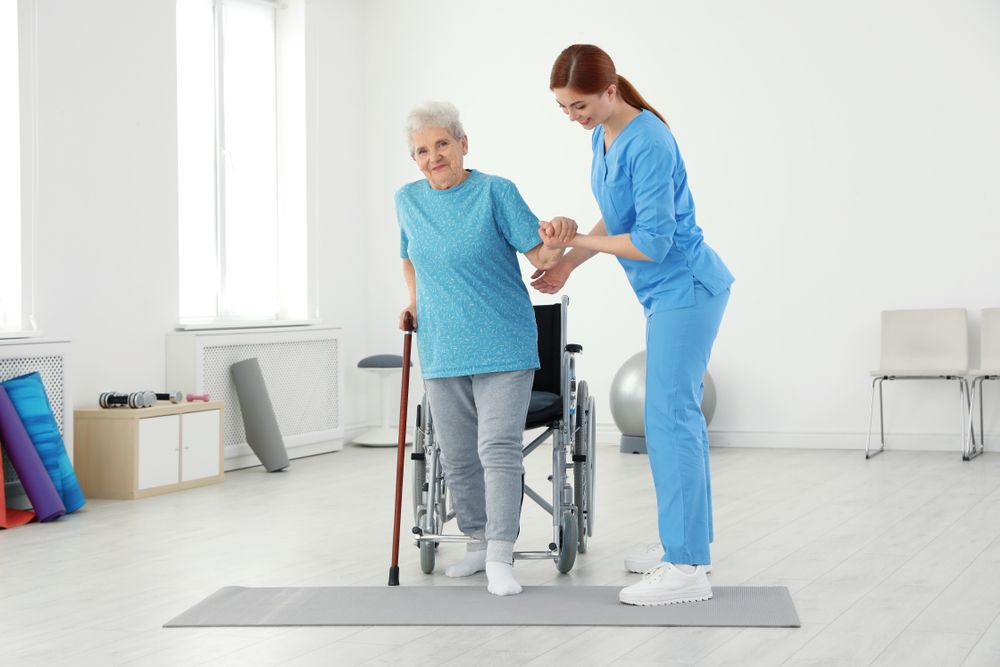 Professional physiotherapist working with elderly patient in rehabilitation center